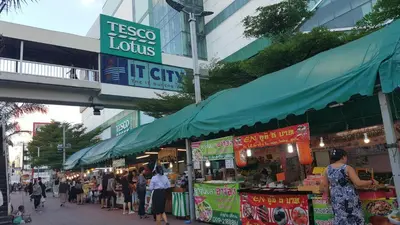 a group of people walking around a street market at Baan Pinklao in Bangkok