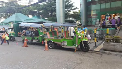 a green golf cart parked on the side of a street at Baan Pinklao in Bangkok