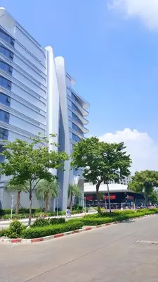 a large white building with trees in front of it at Popular Condo by Jintana in Pak Kret