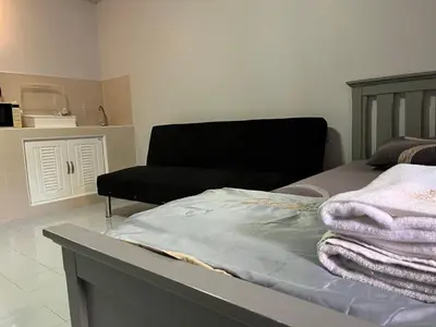 a bedroom with a bed and a couch at Popular Condo by Jintana in Pak Kret