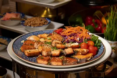 a plate of food with meat and vegetables on a table at Jasmine City Hotel in Bangkok
