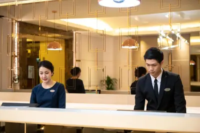 a man and woman sitting at a table in a restaurant at Jasmine City Hotel in Bangkok