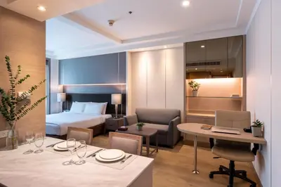 a hotel room with a bed and a table and chairs at Jasmine City Hotel in Bangkok