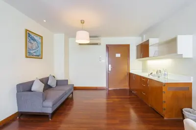 a living room with a couch and a kitchen at Lantana Resort Hotel Bangkok in Bangkok