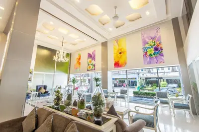 a room with tables and chairs and paintings on the walls at Pratunam City Inn in Bangkok