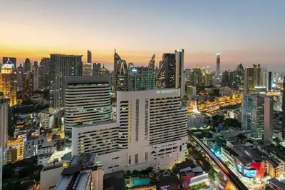 a tall white building in a city at night at JW Marriott Hotel Bangkok in Bangkok