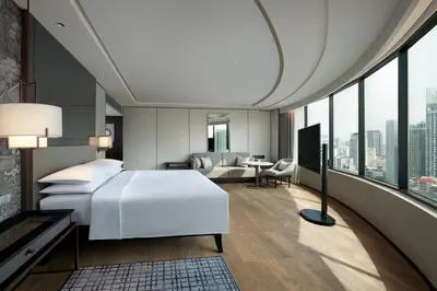 a bedroom with a white bed and a living room at JW Marriott Hotel Bangkok in Bangkok