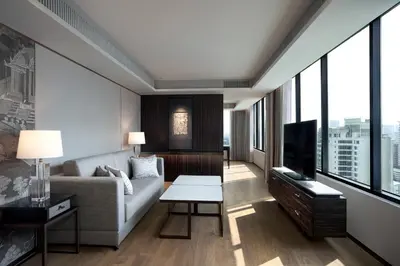 a living room with a couch and a tv at JW Marriott Hotel Bangkok in Bangkok