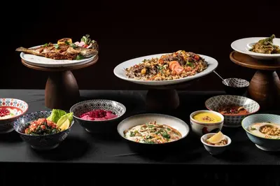 a table with plates of food and bowls of food at JW Marriott Hotel Bangkok in Bangkok