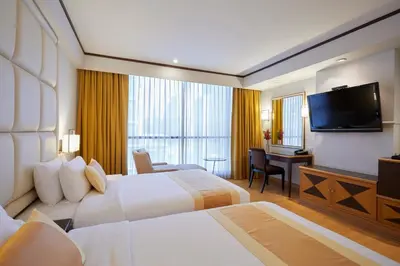 a hotel room with two beds and a flat screen tv at The Four Wings Hotel Bangkok in Bangkok