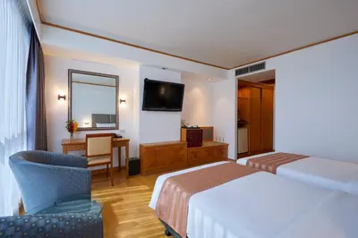 a hotel room with a bed and a desk at The Four Wings Hotel Bangkok in Bangkok