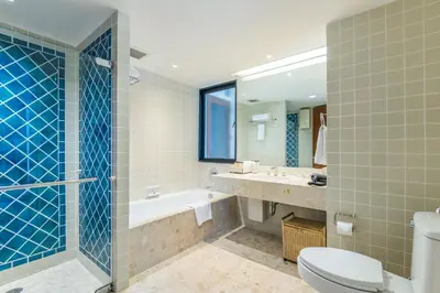 a bathroom with a tub and a toilet and a sink at Chatrium Sathon Bangkok in Bangkok