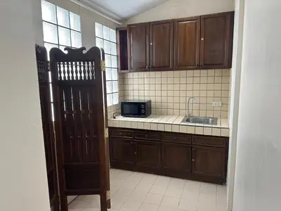 a kitchen with a sink and a microwave at The Siam Heritage Hotel in Bangkok