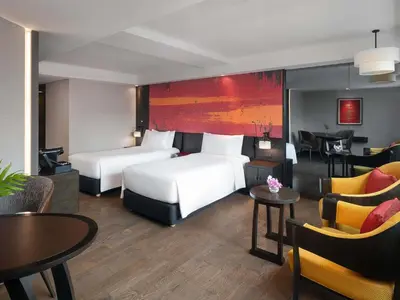 a hotel room with two beds and tables and chairs at Mercure Bangkok Sukhumvit 11 in Bangkok