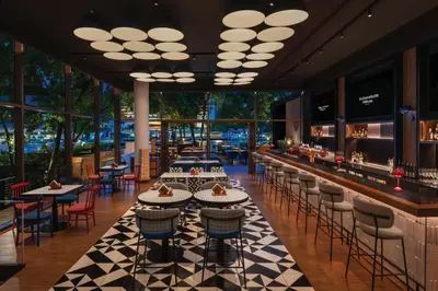 a restaurant with tables and chairs and a bar at Millennium Hilton Bangkok in Bangkok