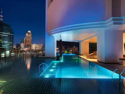 a swimming pool on top of a building at night at Millennium Hilton Bangkok in Bangkok