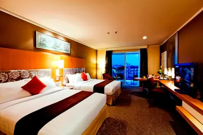 a hotel room with two beds and a television at Royal Princess Larn Luang - SHA Extra Plus in Bangkok
