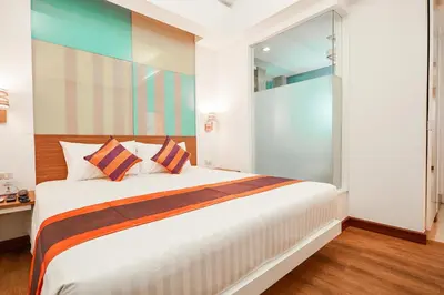 a bedroom with a large white bed and a glass door at Studio Asoke in Bangkok