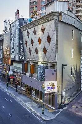 a building with a sign on the side of a street at Studio Asoke in Bangkok