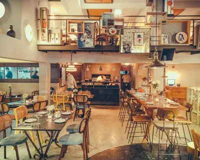a restaurant with tables and chairs and a kitchen at Sacha's Hotel Uno in Bangkok