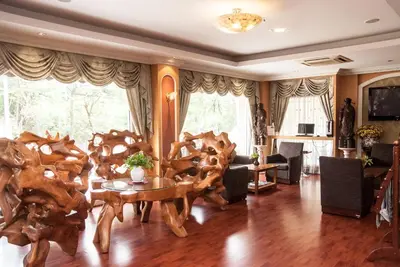 a living room with wooden chairs and a table at Metro Point Bangkok in Bangkok