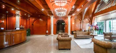 a large room with a lobby with couches and chairs at The Victory Residences Bangkok in Bangkok