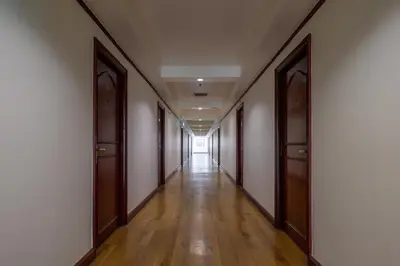 an empty corridor with wooden doors and a long hallway at The Victory Residences Bangkok in Bangkok