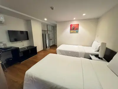 a hotel room with two beds and a flat screen tv at I Residence Hotel Sathorn in Bangkok
