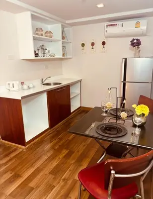 a small kitchen with a table and a refrigerator at I Residence Hotel Sathorn in Bangkok