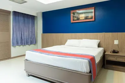 a bedroom with a large bed with a blue wall at Bangkok Loft at Nana Station in Bangkok