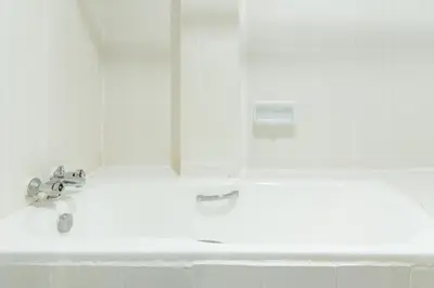 a white bathroom with a sink and a mirror at Bangkok Loft at Nana Station in Bangkok
