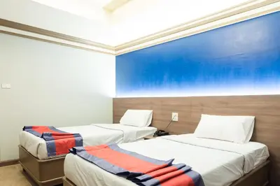 a room with two beds and a blue wall at Bangkok Loft at Nana Station in Bangkok
