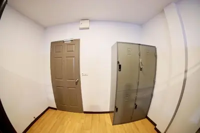 two gray lockers in a white room with wood floors at Inn Trog And Inn Soi in Bangkok