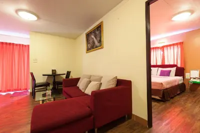 a living room with a couch and a bed at Vabua Asotel Bangkok in Bangkok