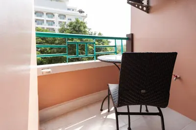 a balcony with a table and a chair and a window at Vabua Asotel Bangkok in Bangkok