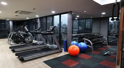 a gym with treadmills and exercise equipment in a building at Citrus Suites Sukhumvit 6 by Compass Hospitality in Bangkok