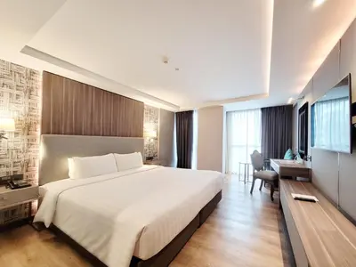 a hotel room with a large bed and a desk at Citrus Suites Sukhumvit 6 by Compass Hospitality in Bangkok