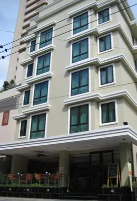 a building with tables and chairs in front of it at The Dawin Hotel in Bangkok