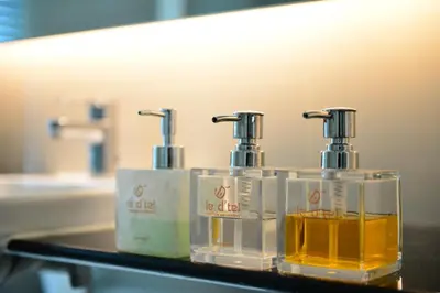 two soap dispensers on a counter in a bathroom at Le D'Tel Bangkok in Bangkok