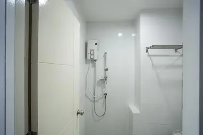 a bathroom with a shower with a glass door at Twentynine KV Apartel in Nonthaburi