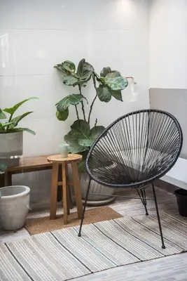 a chair and a table in a room with plants at Aridom Designer Loft House in Bangkok