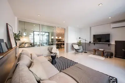a living room with a couch and a tv at Aridom Designer Loft House in Bangkok