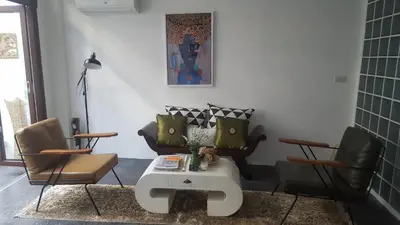 a living room with two chairs and a table at Haus Sathorn 21 Bed and Breakfast in Bangkok