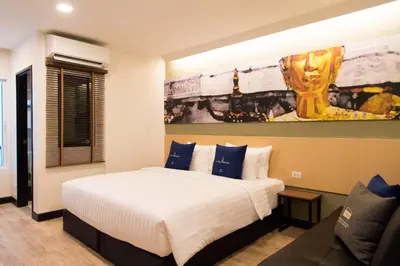 a bedroom with a large bed and a couch at Tarawish Hotel in Bangkok