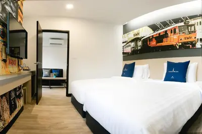a bedroom with two beds with blue pillows at Tarawish Hotel in Bangkok