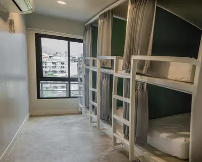 a room with four bunk beds with a window at Yaks House Hostel in Bangkok