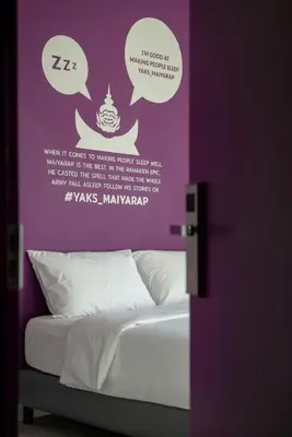 a bedroom with a bed with a purple wall at Yaks House Hostel in Bangkok