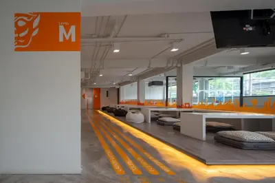 a room with couches and tables in a building at Yaks House Hostel in Bangkok