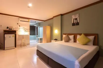 a bedroom with a large bed and a kitchen at Collection O Howard Square Boutique Hotel in Bangkok