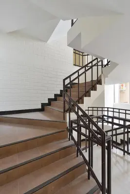 a staircase in a building with a white brick wall at Studio Residence Sukhumvit 71 in Bangkok